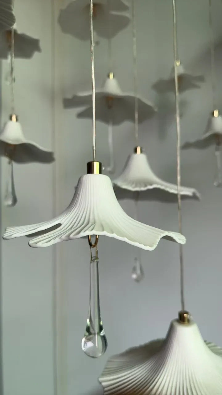 Single ribbed white mushroom shade with hanging crystal drop on a wire cord