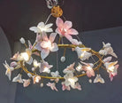 Hanging ceramic flower chandelier with soft pink and white petal lights on gold branches