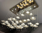 Mushroom ceramic chandelier overhead view with glowing white shades on hanging wires