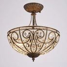 Gold-tone flush-mount chandelier close-up with crystal-style glass accents and intricate scrollwork