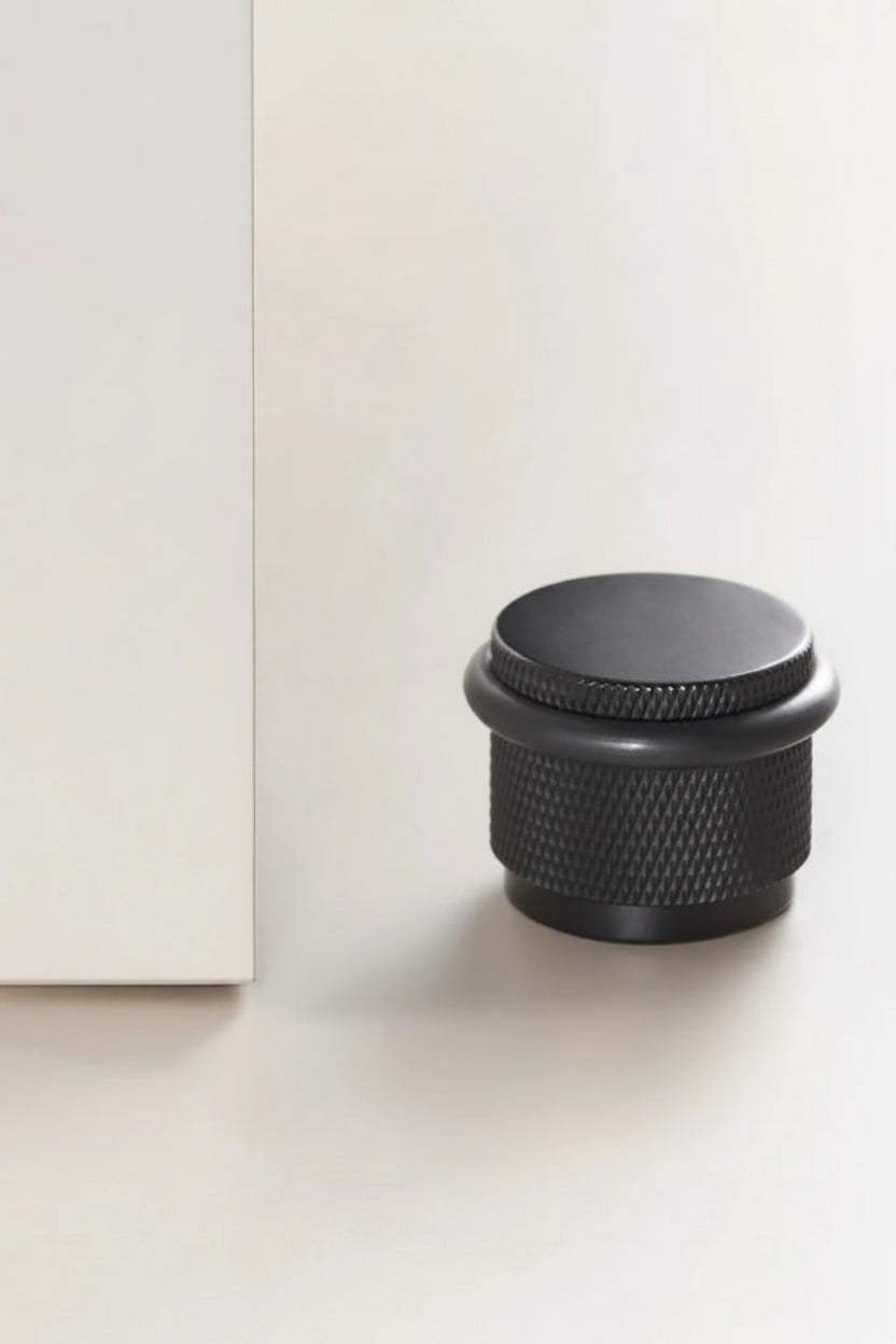 Black textured knob on a white surface with 'Nurlin' branding.