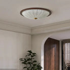 Walnut round flush-mount ceiling light with clear ribbed acrylic diffuser on white ceiling