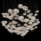Mushroom-style ceramic chandelier with multiple glowing white shades on long metal cords