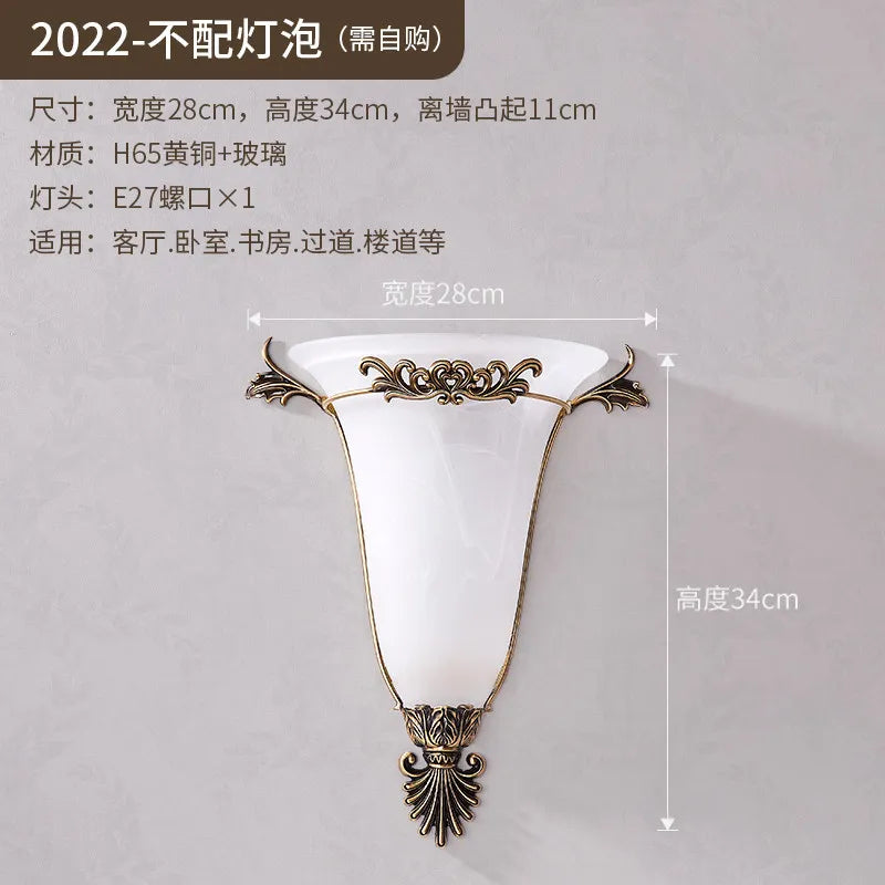 Gold wall sconce with frosted glass shade and vintage scroll metal mount